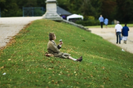 Kobieta-probujaca-wino-na-trawniku-w-parku-w-St-Germain-en-Laye,-Francja